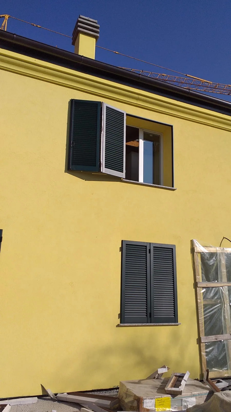 Dettaglio di serramento in PVC e persiana in alluminio installati sull’edificio residenziale.