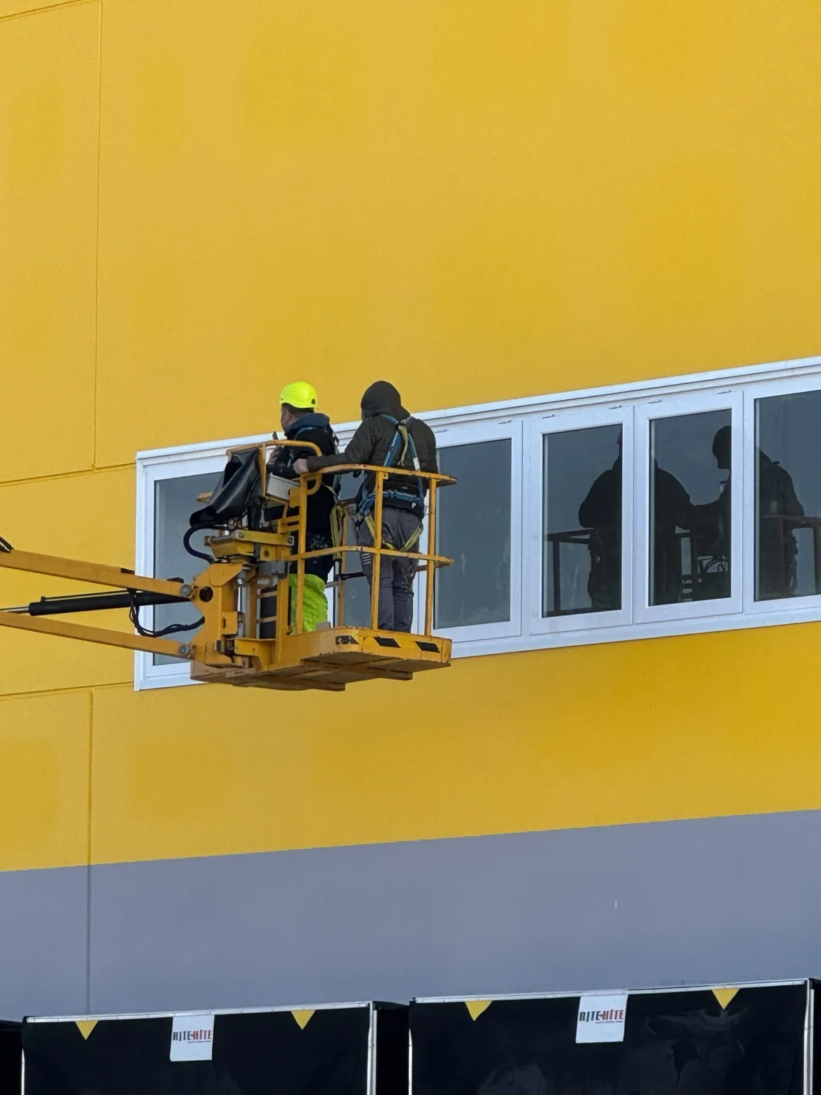 Operai su piattaforma durante la regolazione dei serramenti DHL Express.