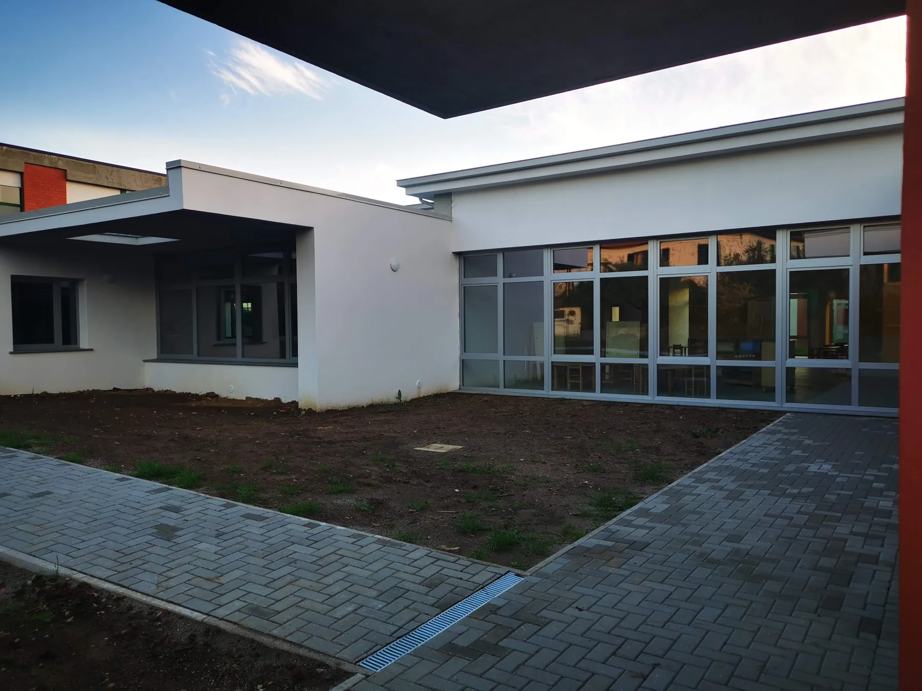 Corte interna della Scuola dell’Infanzia di Pacciana con ampie superfici vetrate.