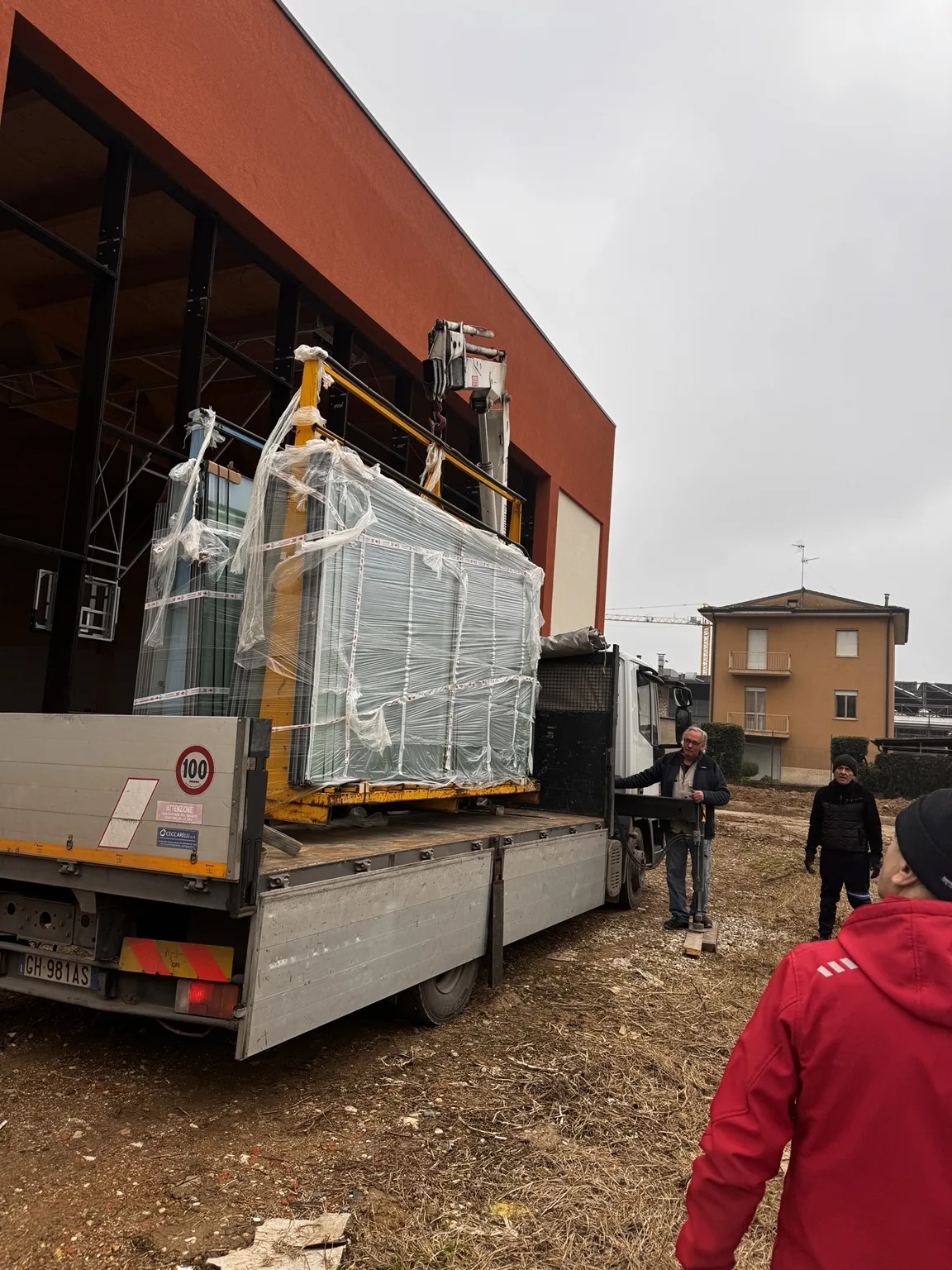 Consegna e movimentazione dei serramenti nel cantiere della Scuola Gianni Rodari di Parma.